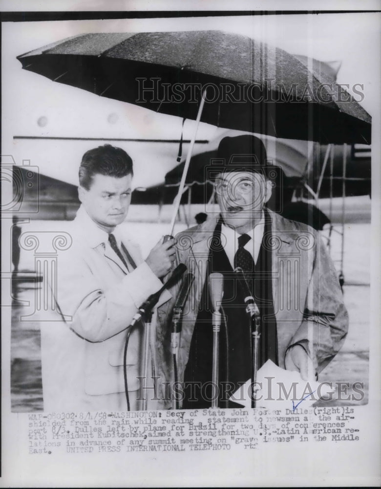 1958 Secretary of State John Foster Dulles shielded from the rain - Historic Images