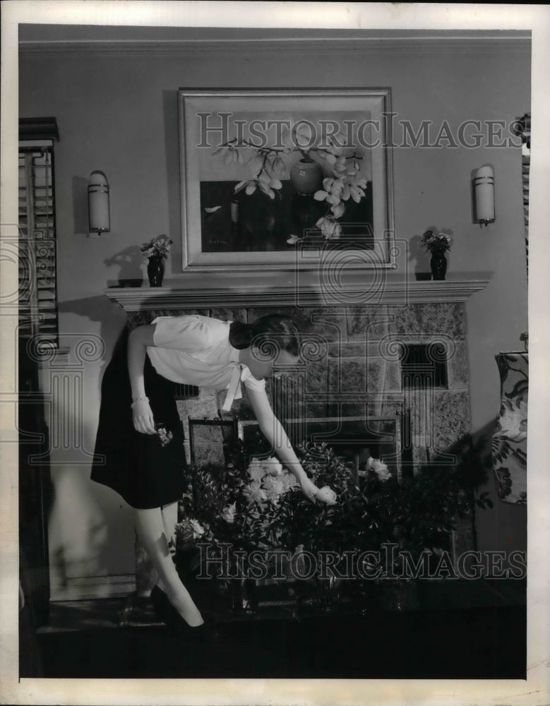 1945 Press Photo A lady hides livingroom fireplace with plant screen - Historic Images