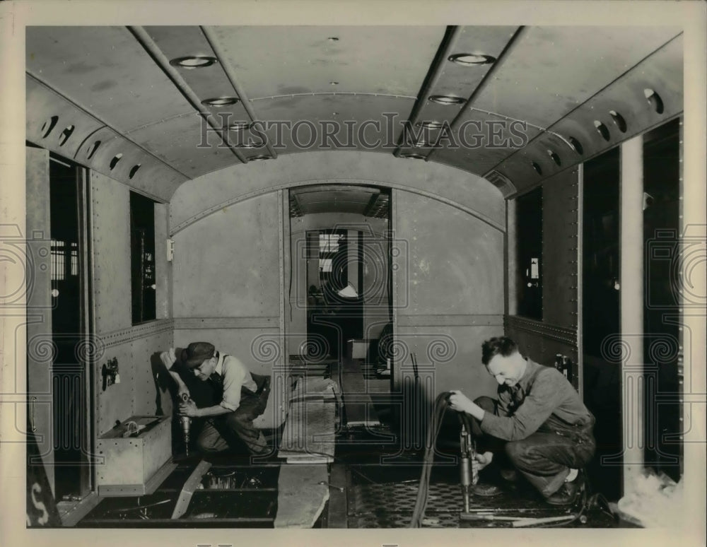 1989 Workmen installing aluminum flooring for the Rapid Transit. - Historic Images
