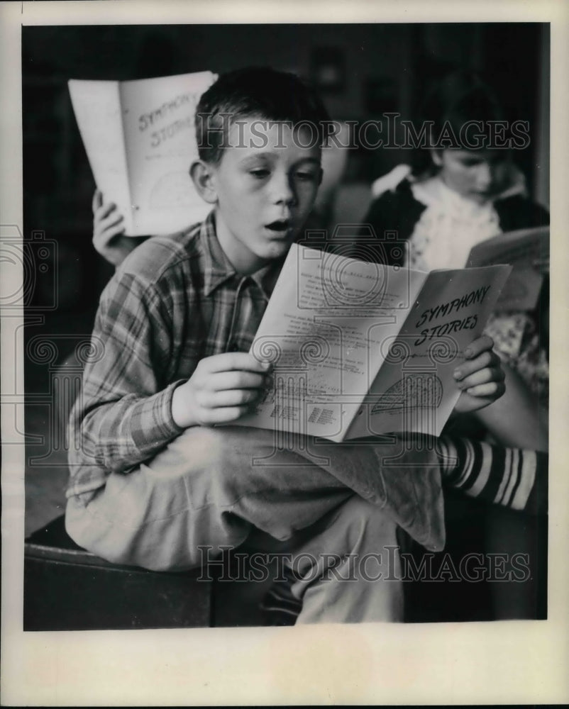 1948 Press Photo Teddy Moore reading Symphony Stories - nea27714 - Historic Images