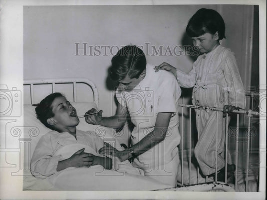 1945 Press Photo Marvin Stoddard examined by Dr Joseph West as his sister - Historic Images