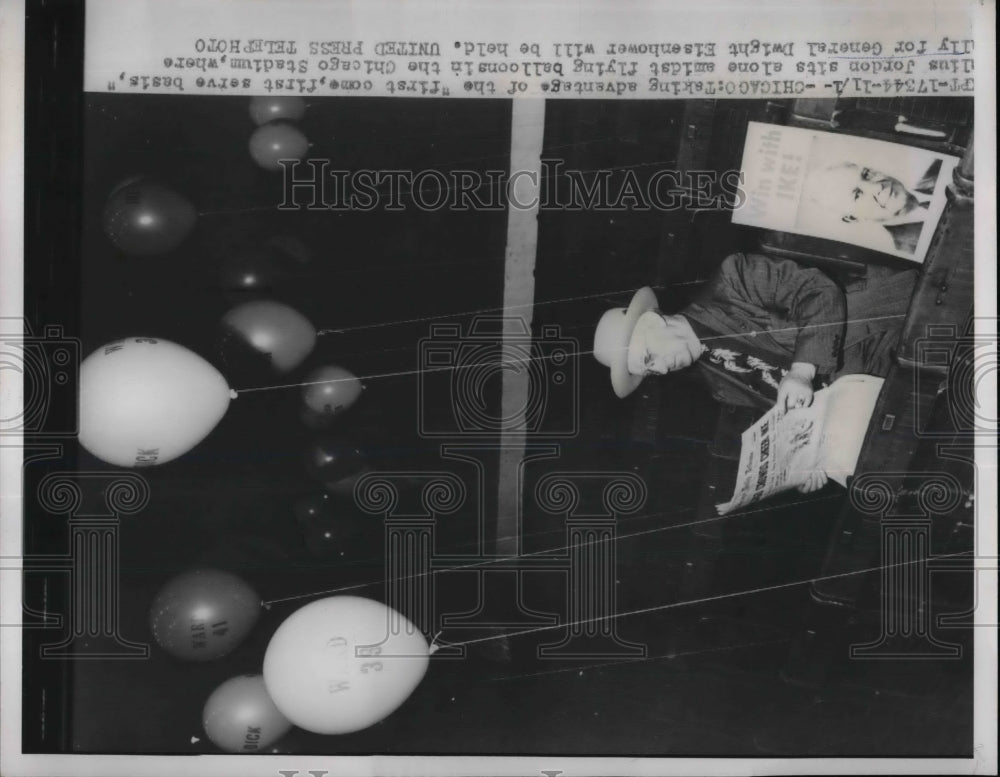1952 Julius Jordon sitting amidst flying balloons in the Chicago - Historic Images