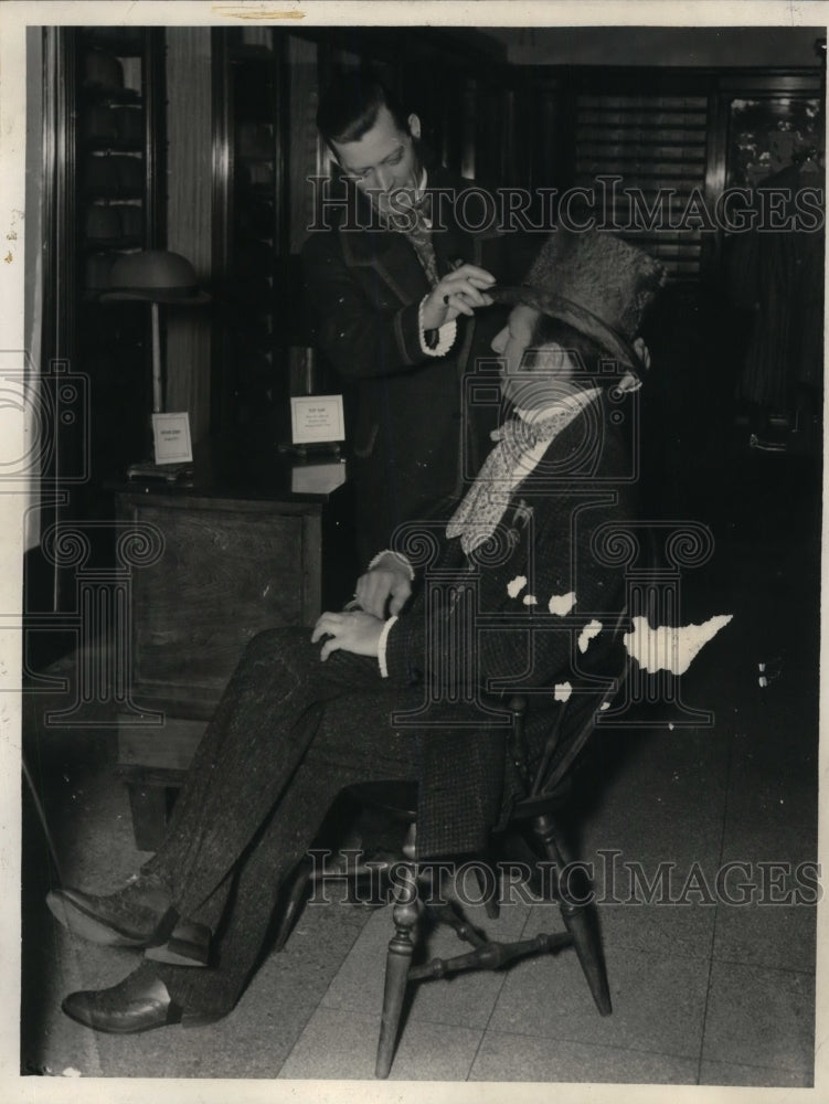 1940 Press Photo Ferd Ziegler tries on collection of topper hats E.A. Regage - Historic Images