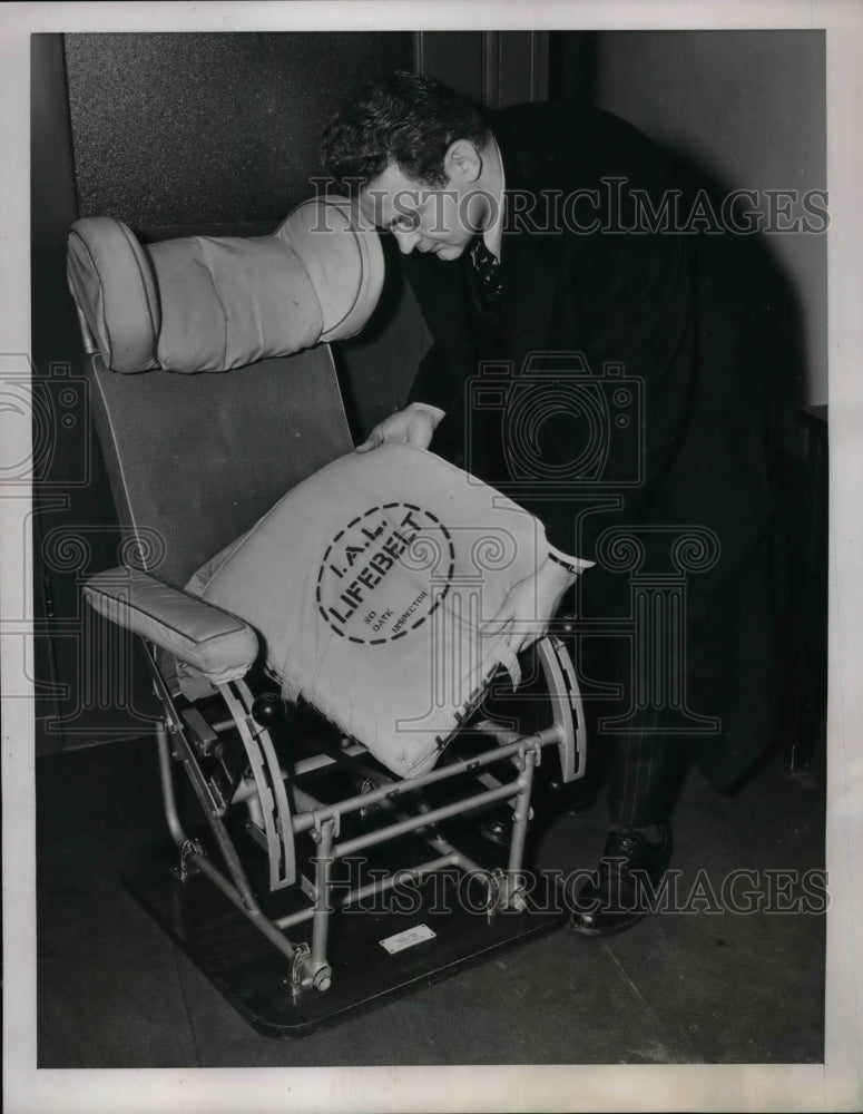 1939 Press Photo Reporter Examines Life Belt Aboard Passenger Plane - Historic Images