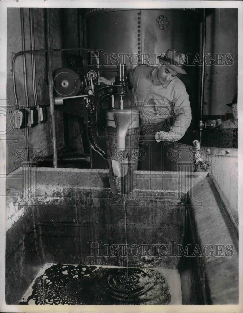 1942 Press Photo John Reimbolt Watches Shark Liver Mixture Runs Into Tank-Historic Images