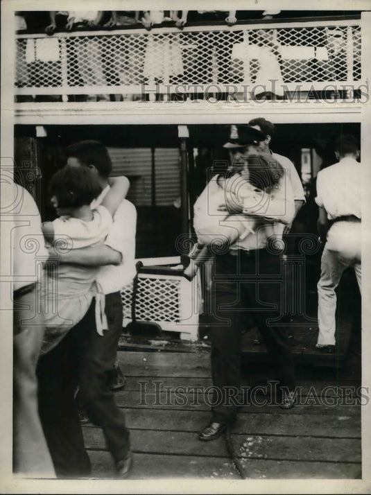 1932 Children being taken off of ship by Policeman - Historic Images