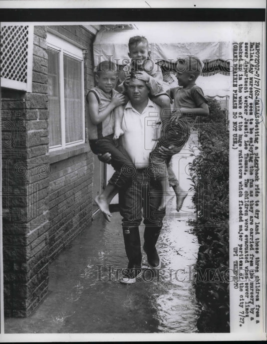 1962 Press Photo Children carried by Sewer Dept worker Jessie Lee Thomas - Historic Images
