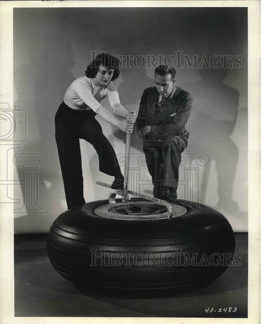 1943 Tool loosen huge Airplane tire from its rim in Firestone. - Historic Images