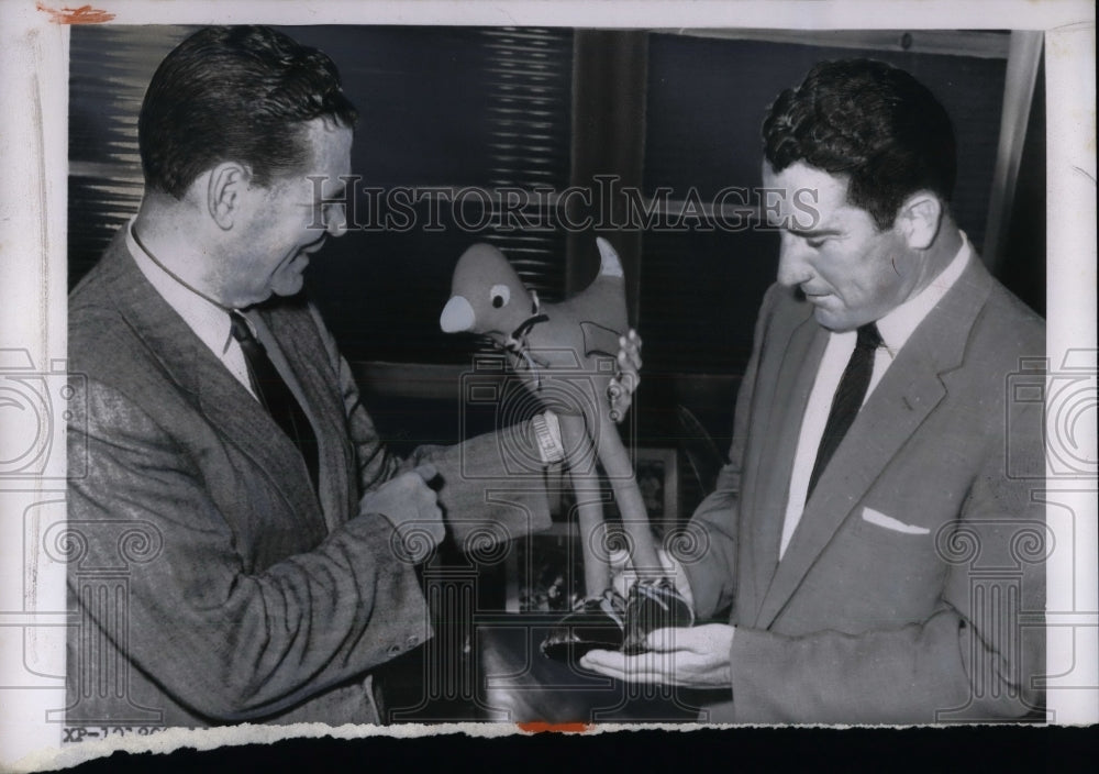 1955 Press Photo Frank Lane looks over a cardinal doll at a press conference-Historic Images