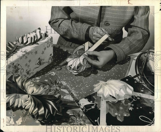 A person decorationg with tied bows - Historic Images