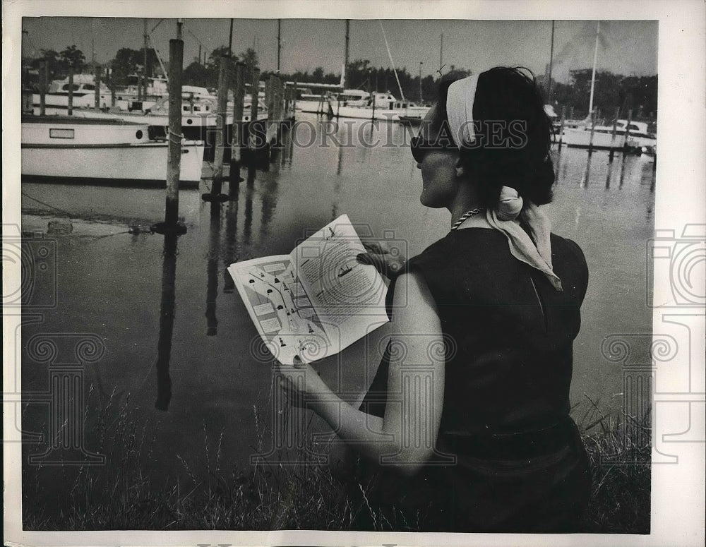 1960 Woman read a Coast Guard&#39;s Recreational Boating Guide. - Historic Images