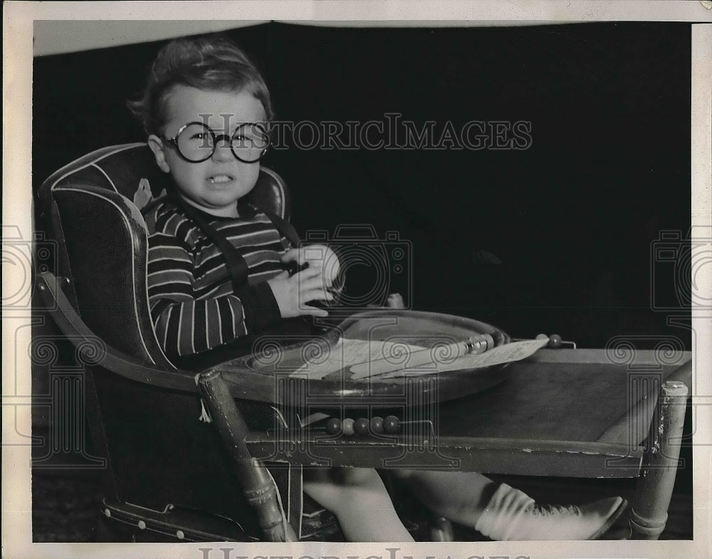 1939 A child in his high chair in talk of child income tax - Historic Images