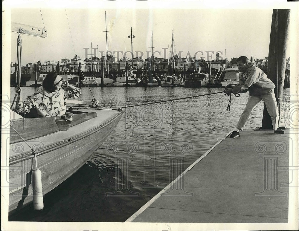 1963 Sailboat being moored to a floating dock - Historic Images