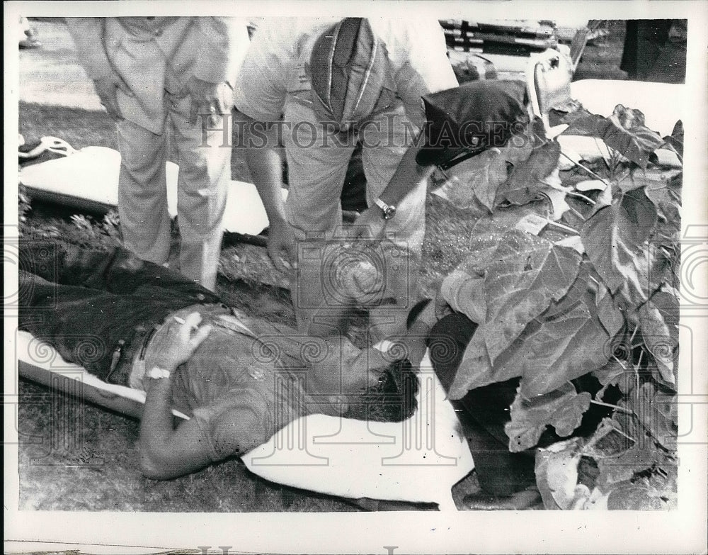 1961 Air Force Officer giving aid to Don Tuttle after jet crash - Historic Images