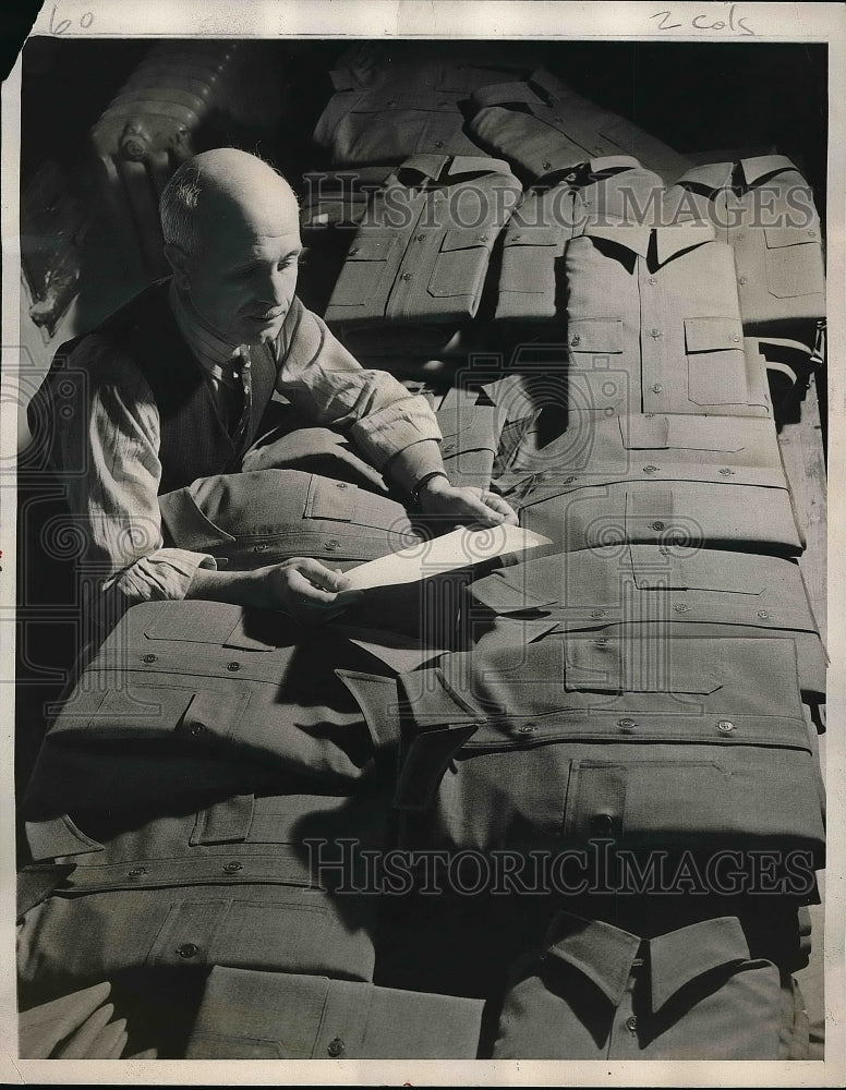 1940 Press Photo Louis Schwarz checking over order of uniform shirts - nea51997 - Historic Images