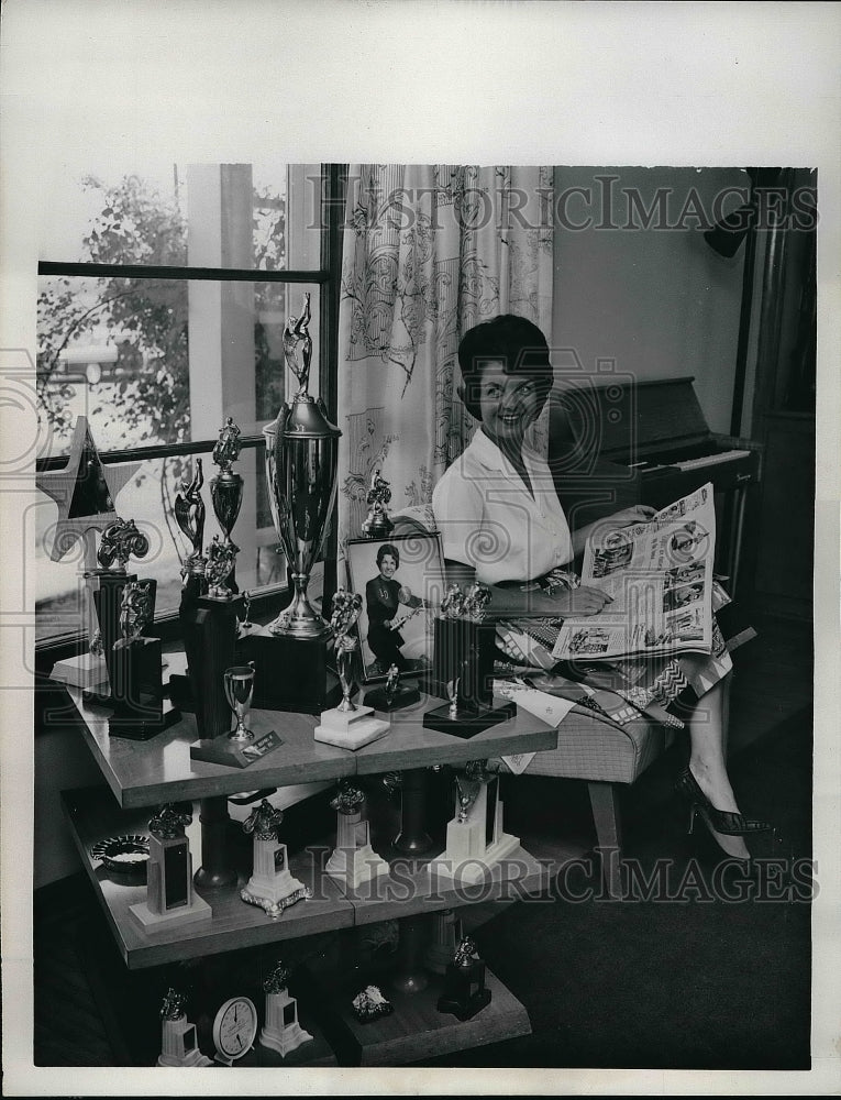 1962 Lilyan DeVore Relaxes By Table Of Motorcycle Event Trophies - Historic Images