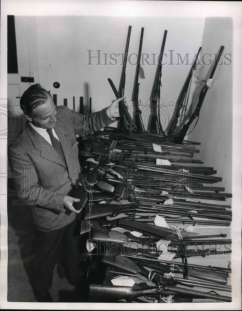 1953 Press Photo Employee Inspecting Confiscated Weapons At Bavarian Ministry - Historic Images