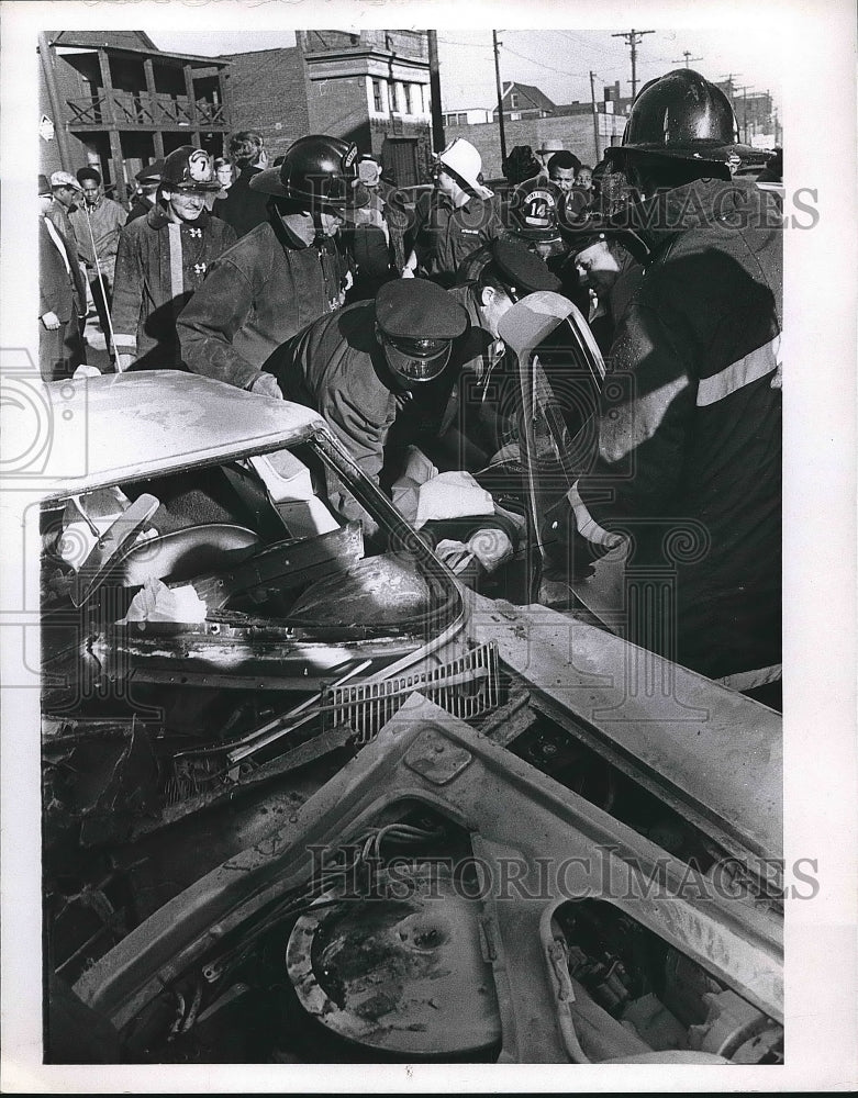 Rescue workers pulling bystander out of wrecked car  - Historic Images