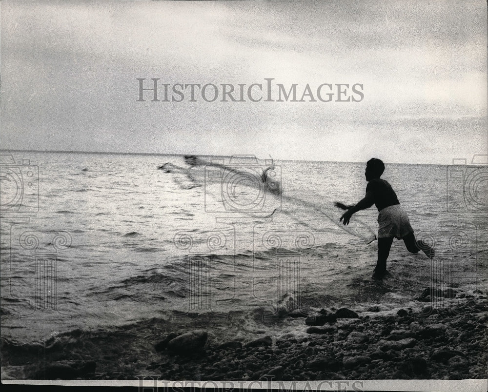 1966 A man net fishing off the coast of Direction Island; a part - Historic Images