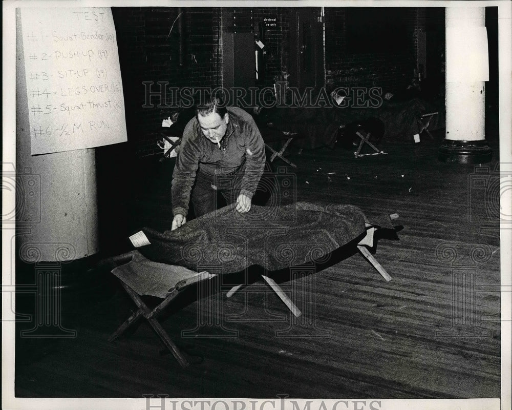 1965 Ernest Kirsh makes up his cot at a Armory due to the transit - Historic Images