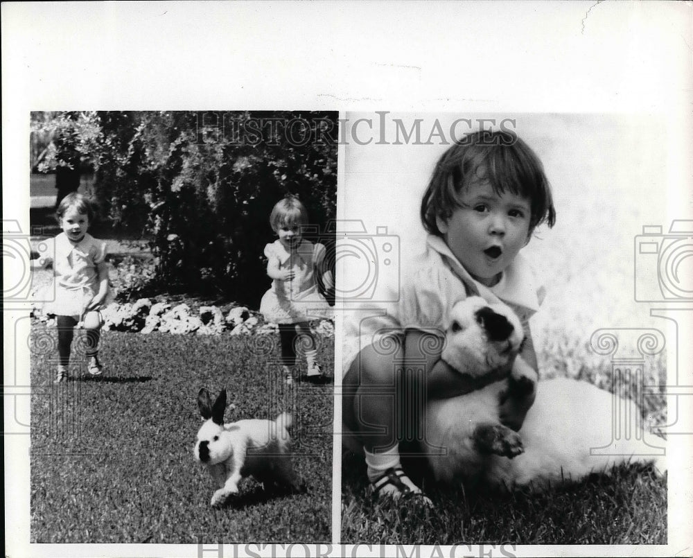 1970 Terri Booth and her twin sister Sherri playing with rabbit - Historic Images