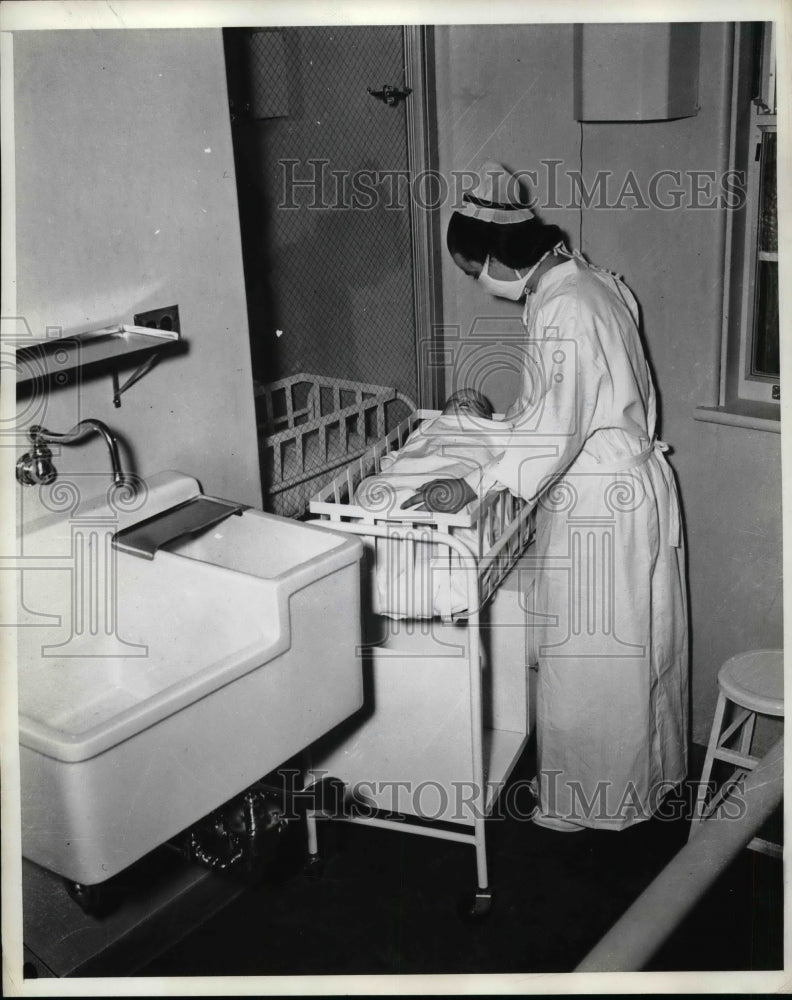 1939 Press Photo Nurse Placing Baby Into New Crib in Evanston - nea58281 - Historic Images