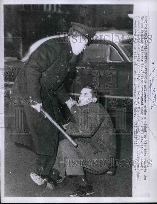 1961 A policeman grabs a picket outside United Nations Building - Historic Images