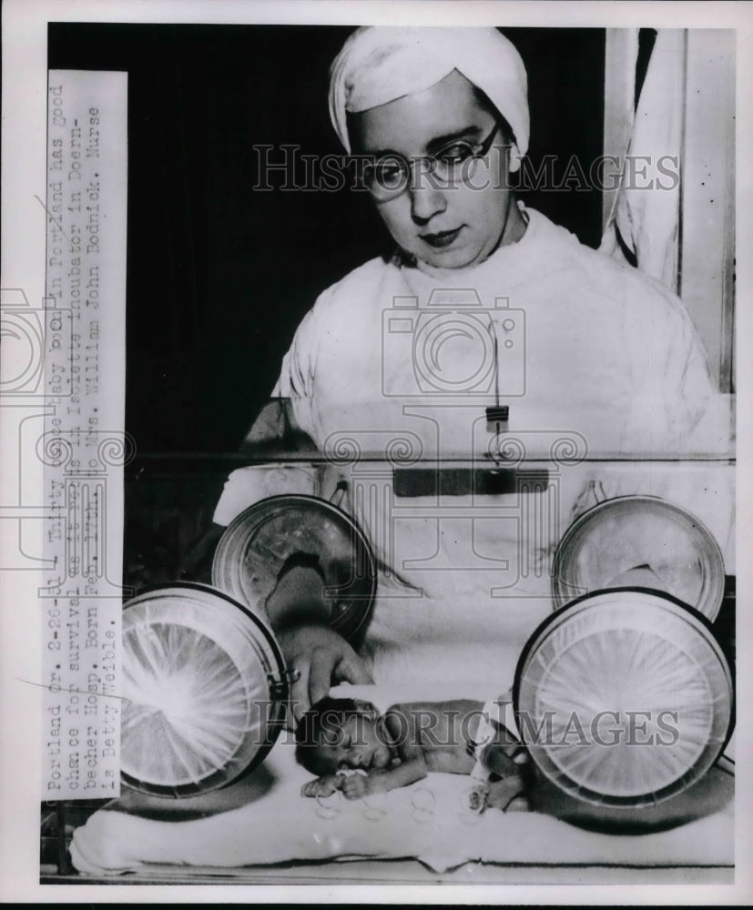 1951 Nurse Betty Weible taking care of a baby in a incubator. - Historic Images