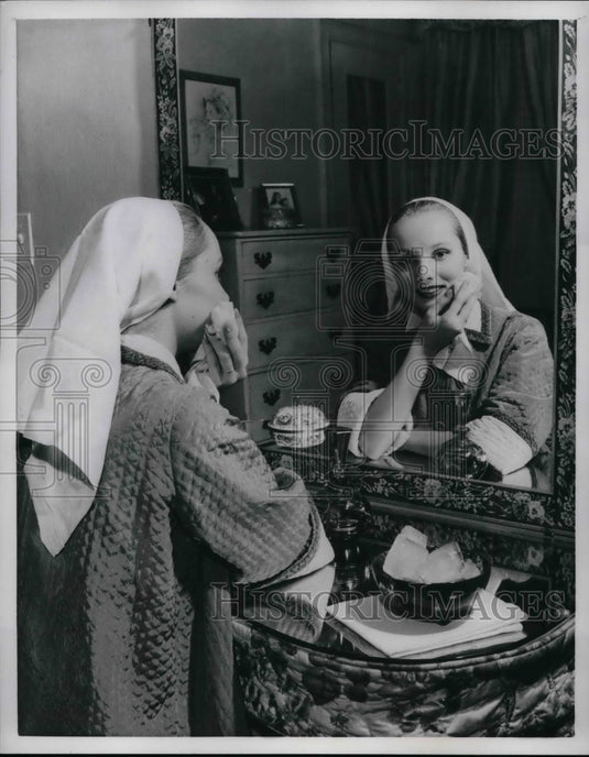 1957 Press Photo Skin Care Rubbing ice cubes wrapped in cloth - nea59762-Historic Images