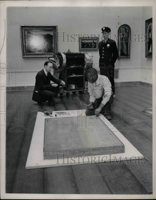 1941 Heavy wire being attached to painting  - Historic Images