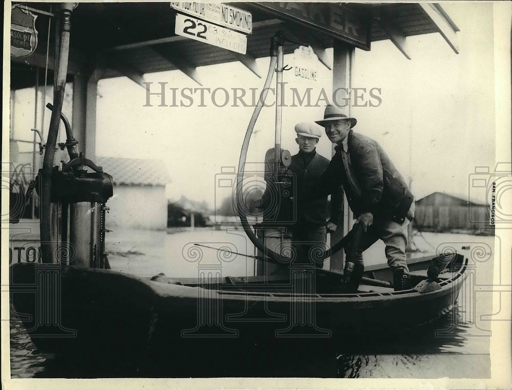 1930 Press Photo man in a boat getting gas at gas station after a flood - Historic Images