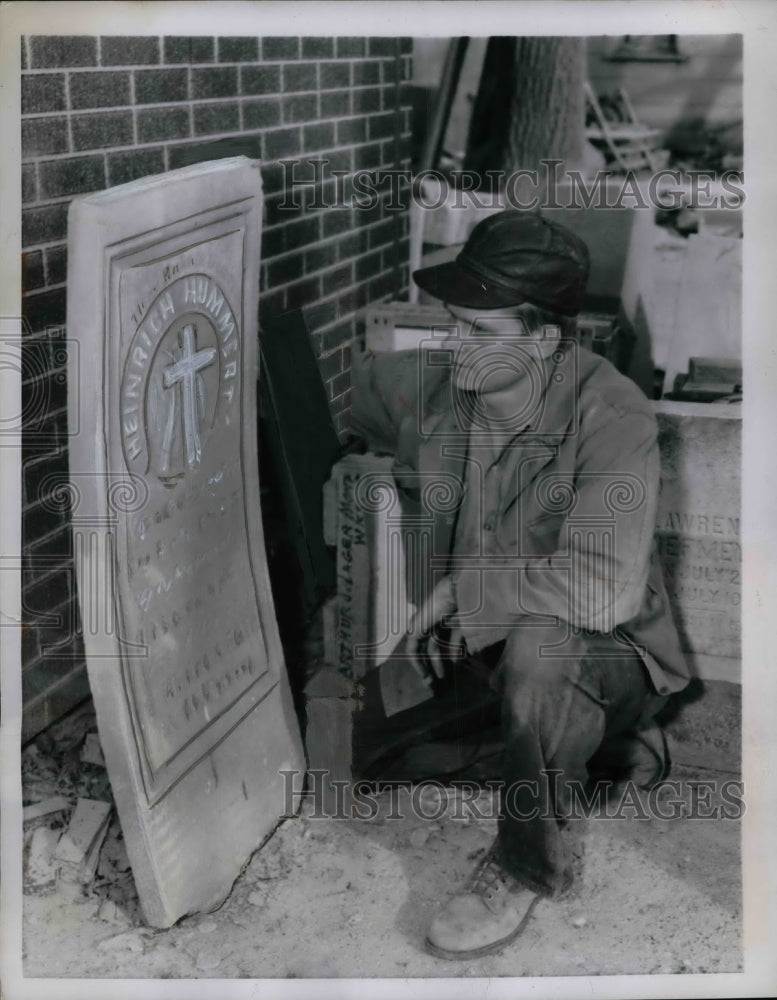 1958 Lawrence Macke inspects ruined gravestone - Historic Images