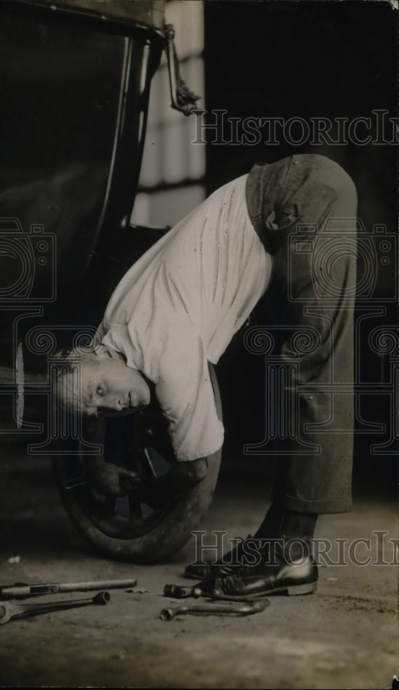 1916 A man bending to fix car  - Historic Images
