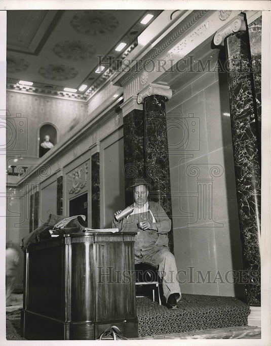 1950 Press Photo Man Sitting At Desk Pouring Drink Into Cup - nea69338 - Historic Images