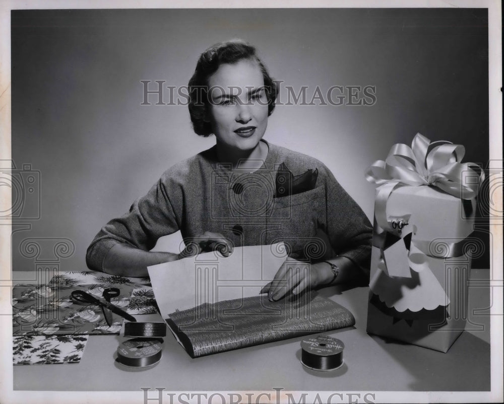 1956 Press Photo A woman wrapping presents in paper &amp; ribbons - nea69631 - Historic Images