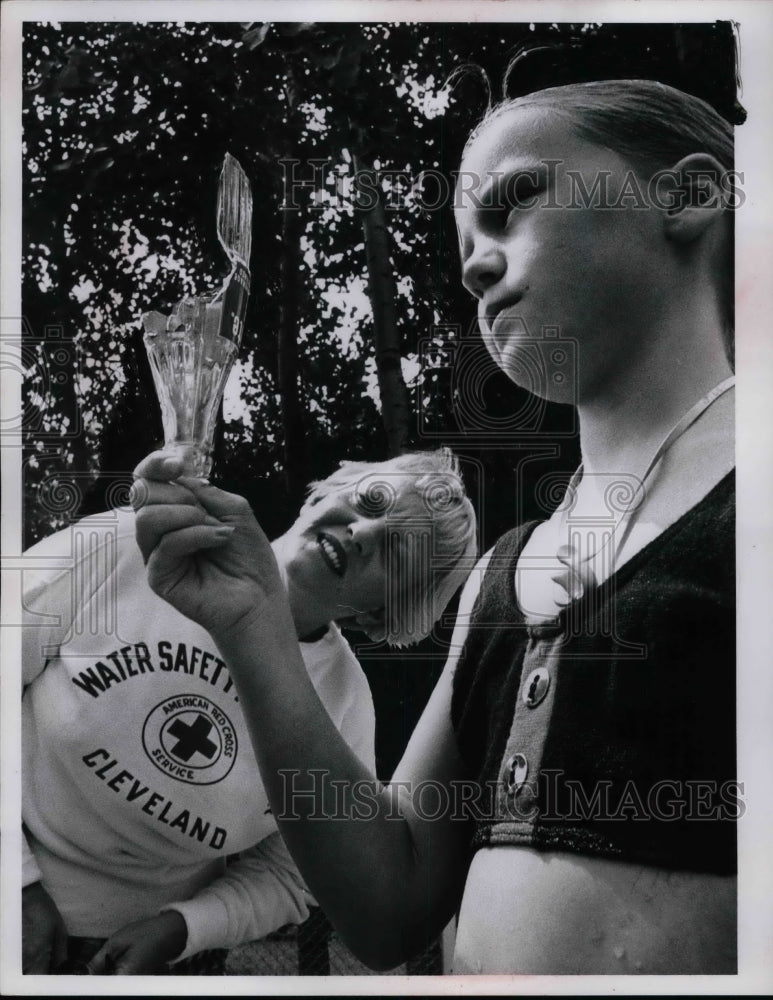 1954 Mrs.Kenneth Wessle of Red Cross and Jill Zajac hold a bottle. - Historic Images