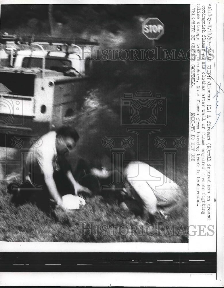 1959 Press Photo Policemen and firemen putting out fire on injured man - Historic Images