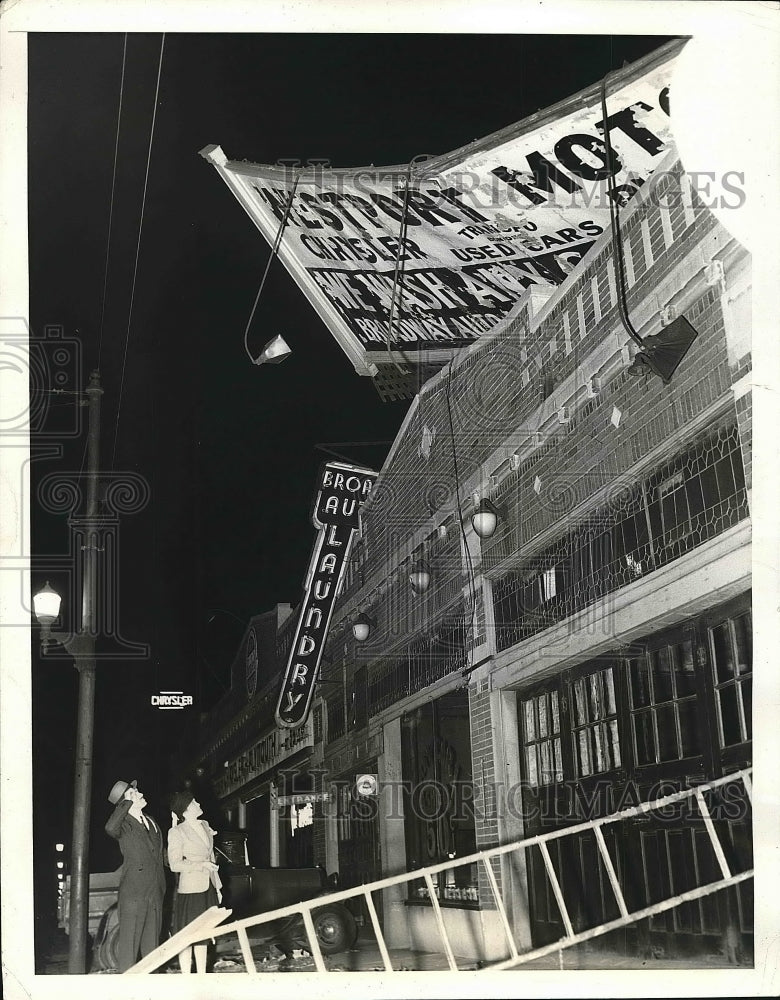 1940 Press Photo John Hampton and Helen Gallagher looking at wind damaged sign - Historic Images