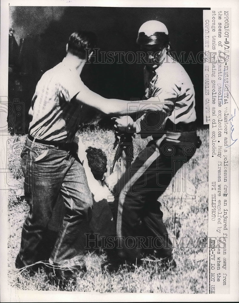 1959 Press Photo A volunteer &amp; policeman drag an injured fireman away from the - Historic Images