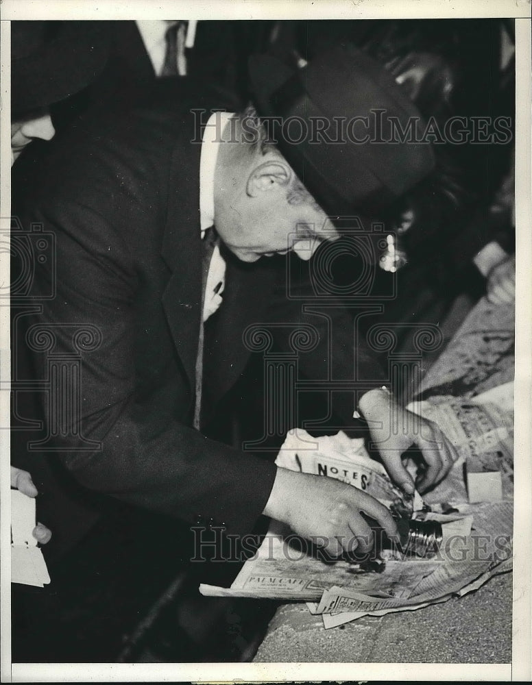 1937 Lieut. William Baker gathering bomb fragments  - Historic Images