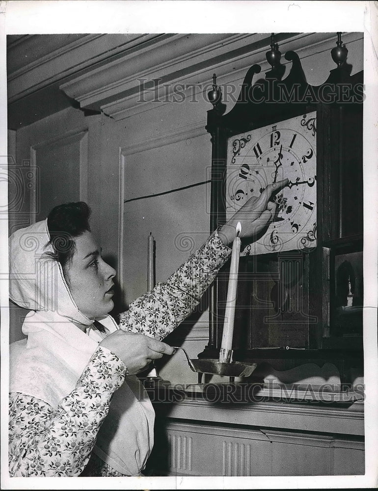 1957 Press Photo Mary E. Welch Raises her candle to Historic Clock - nea73506 - Historic Images