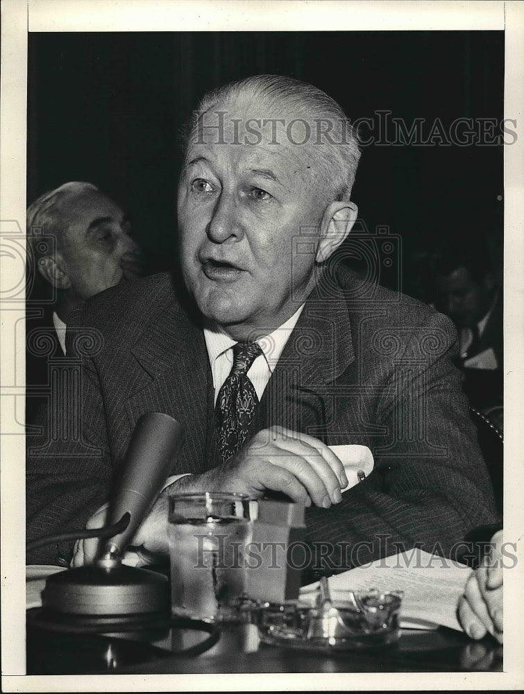 Press Photo Man Sitting At Table With Microphone Speaking - nea73962-Historic Images
