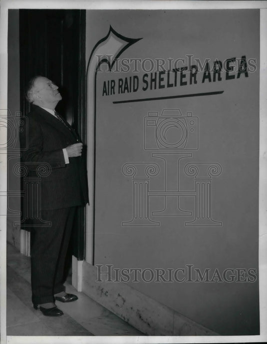 1942 Senator Robert Wagner looking at a shelter sign  - Historic Images
