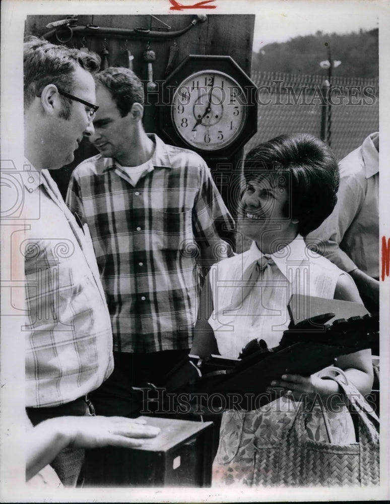 1969 Dave Clum & Mrs. J. Melvin Andrews discuss the price of a wall - Historic Images