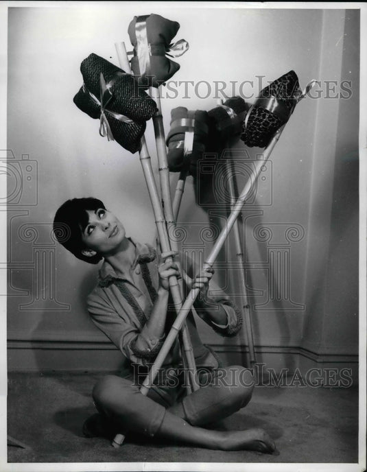 1960 Sheer American woolens bundled and tied to a stick  - Historic Images