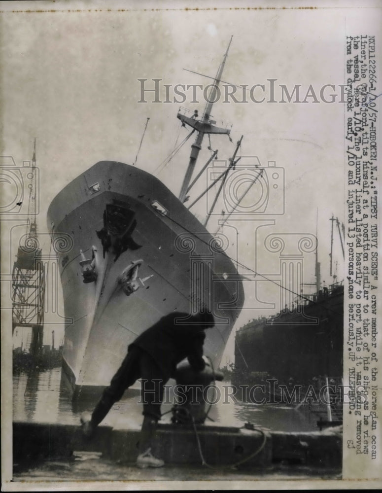 1957 Press Photo Crew Member Watching Norwegian Ocean Liner Tiling in Dock-Historic Images