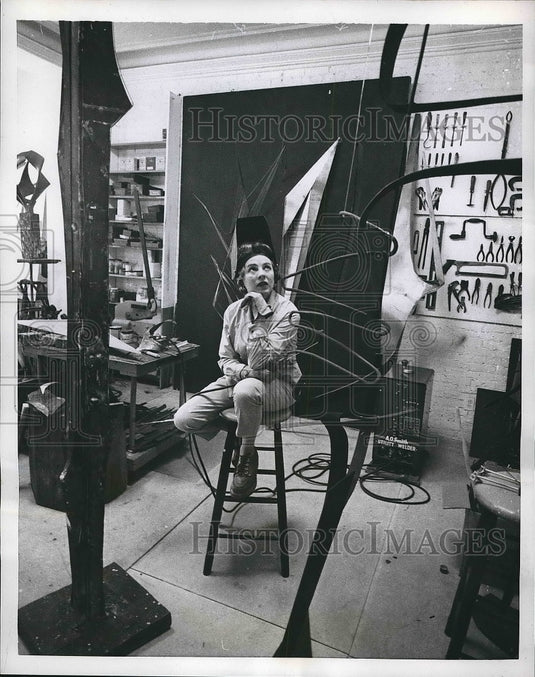 1959 Gwen Luz, sculptress, poses amid the bits and pieces of steel - Historic Images