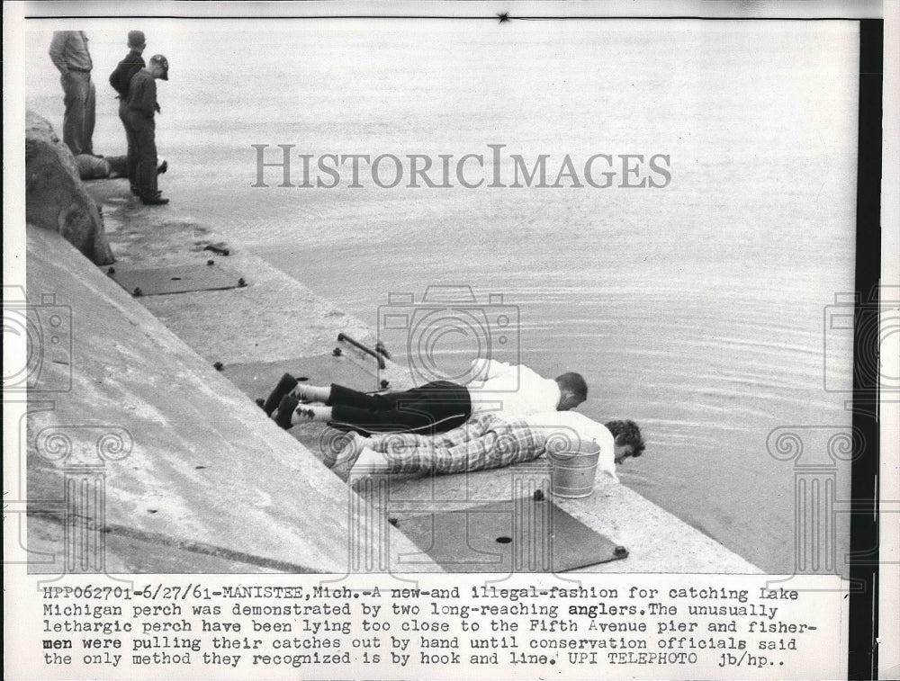 1961 fishermen catching perch by hand off pier, Lake Michigan - Historic Images