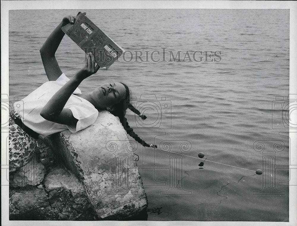 1961 Christina Herdson fishing with her hair  - Historic Images