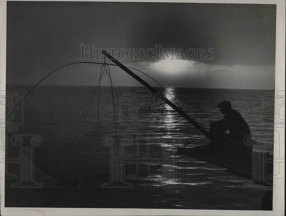 1936 Press Photo A lone fisherman at sunset on his boat - nea79531 - Historic Images